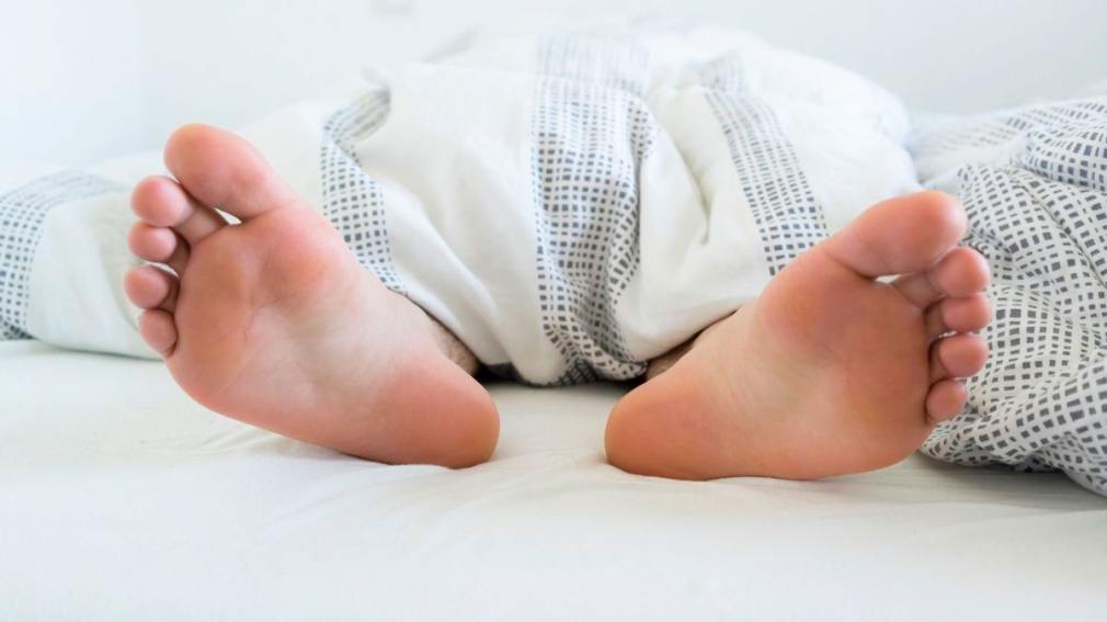 Según la psicología: ¿qué significa dormir con los pies fuera de la sábana?